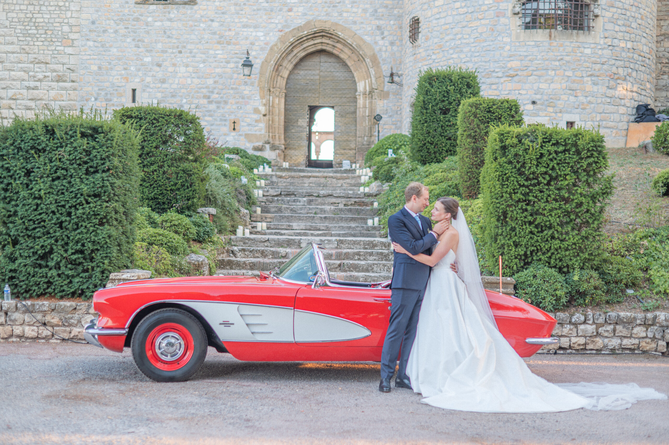 Mariés et voiture de collection devant un château